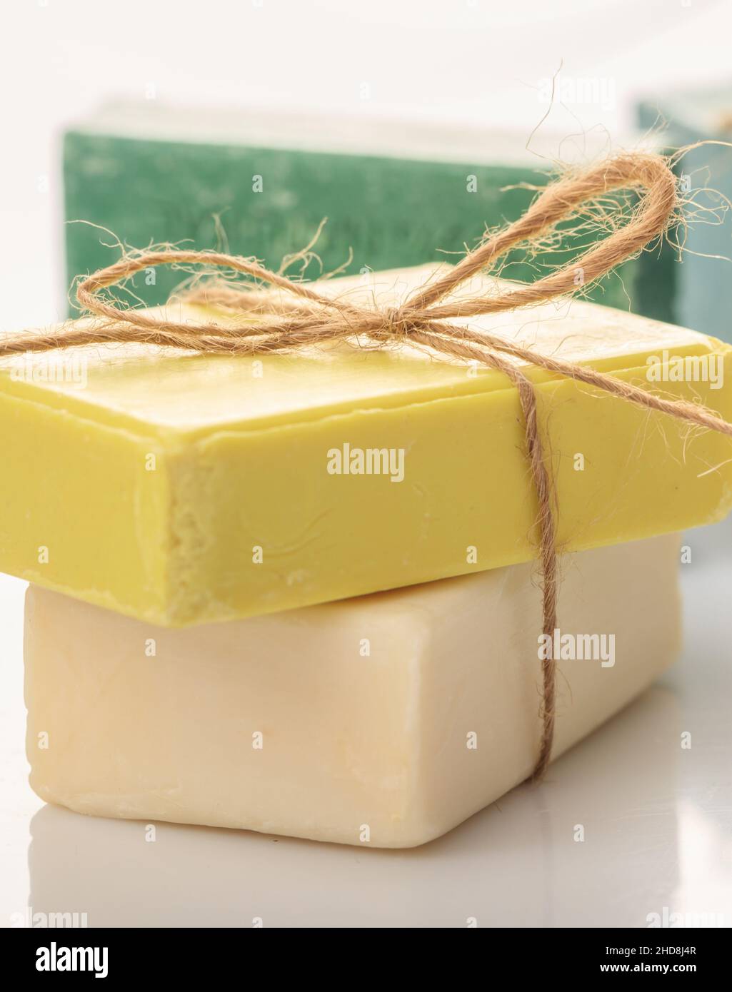 Handmade soap bars tied with rope on white background. Luxury green, yellow, pink bath soap from olive, honey aromatherapy spa refresh healthcare hygi Stock Photo