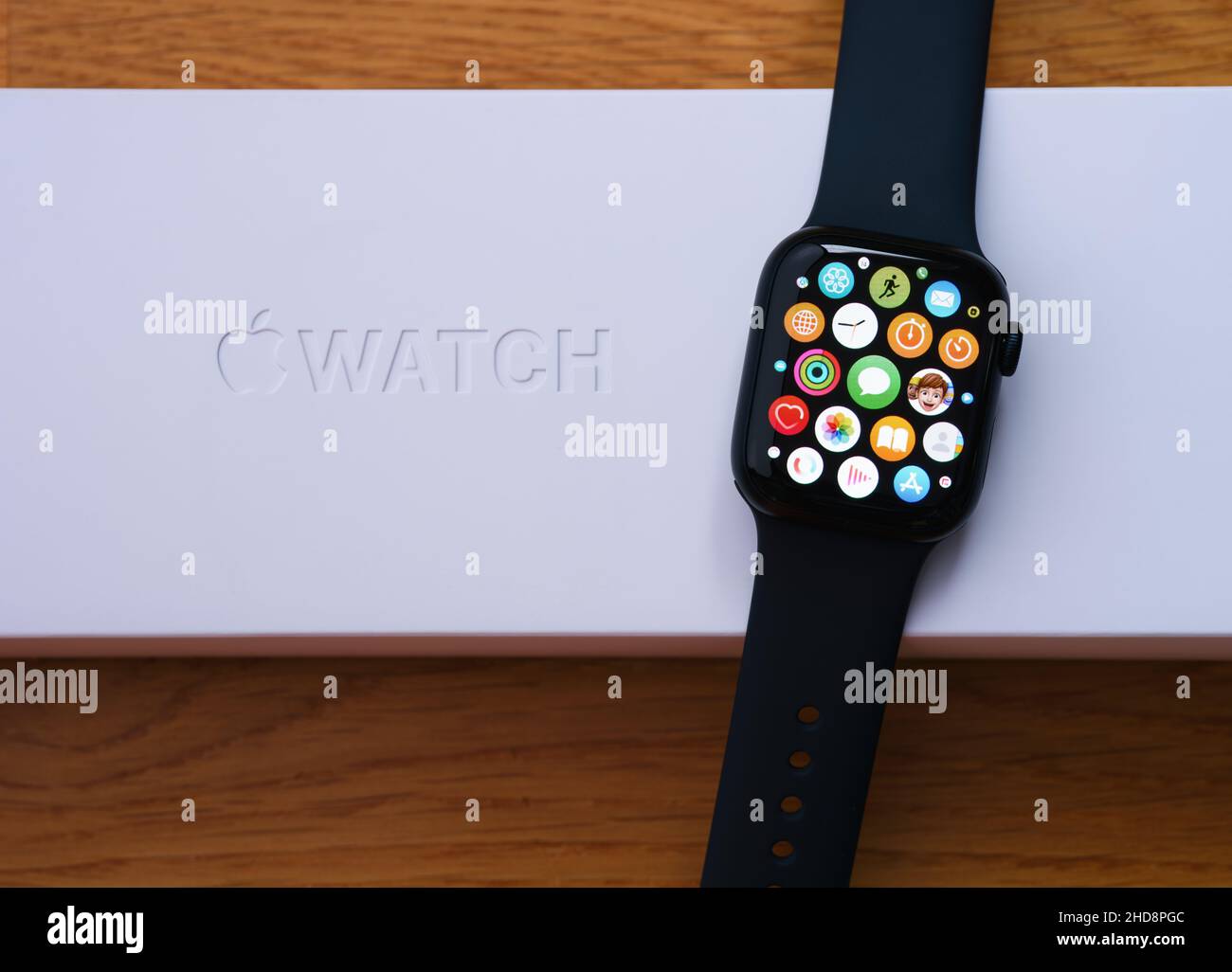 Tambov, Russian Federation - December 14, 2021 An Apple Watch series 7 with apps on its screen lying on its box. Wooden background. Stock Photo