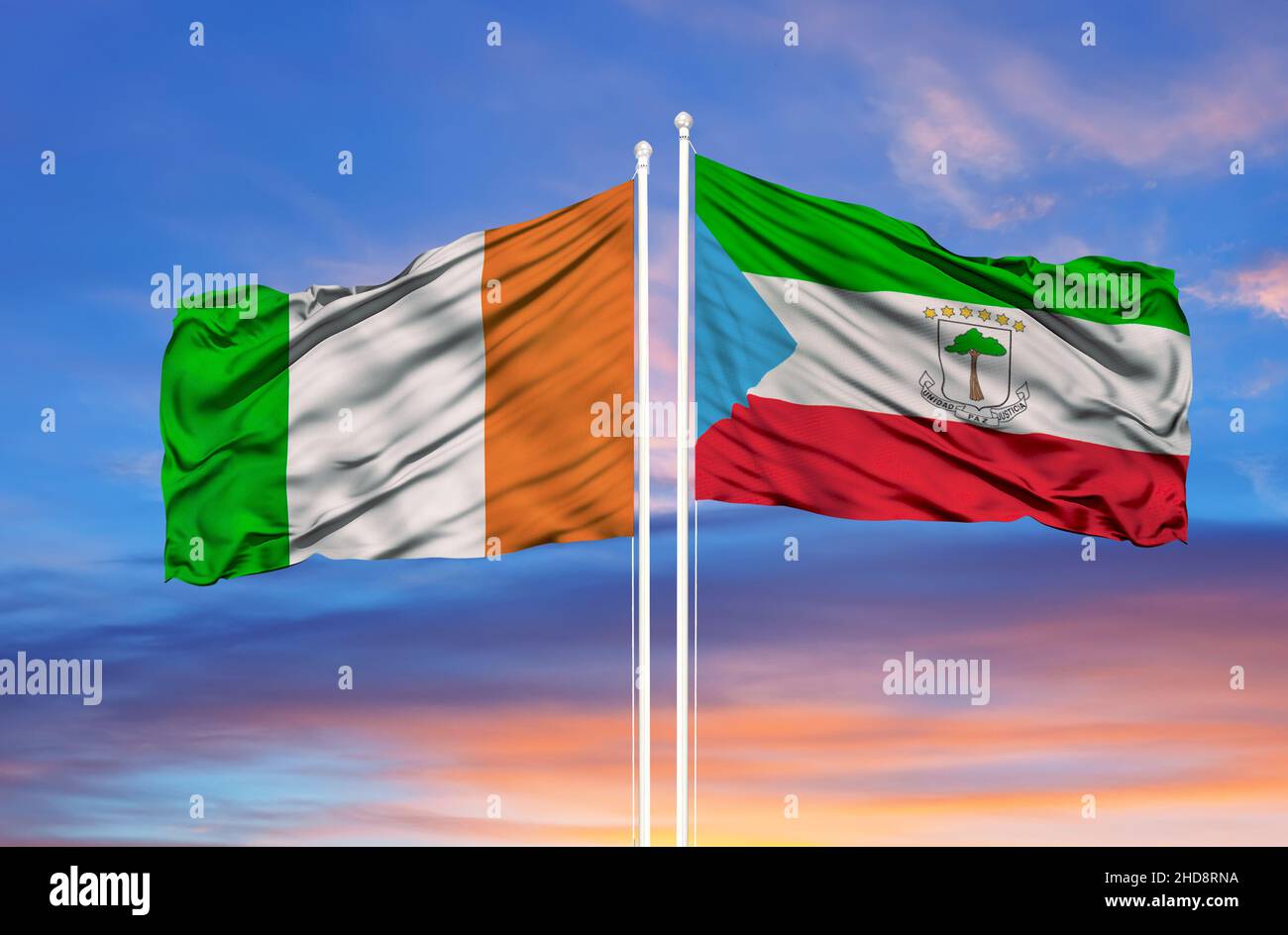Ivory Coast and Equatorial Guinea two flags on flagpoles and blue cloudy sky Stock Photo