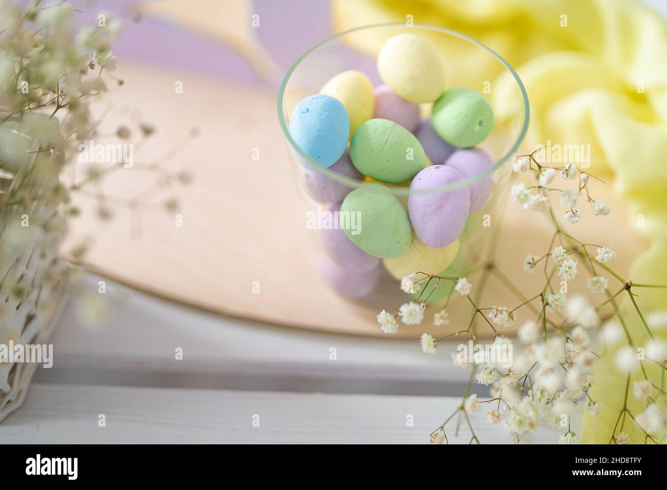 Flower composition with easter colorful dyed eggs in a glass container. Easter composition. Stock Photo