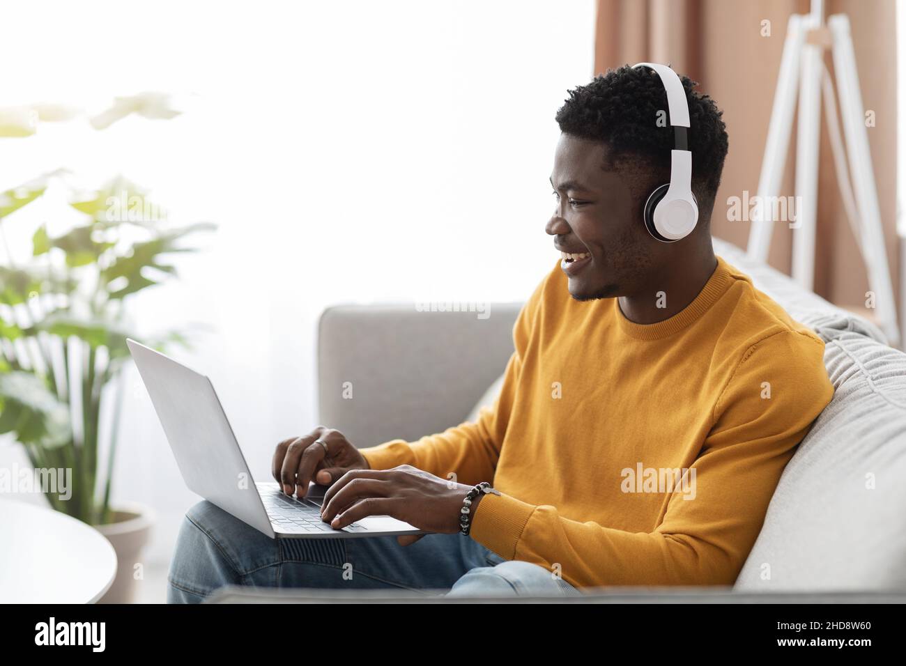 Handsome black guy having webinar, using laptop at home Stock Photo