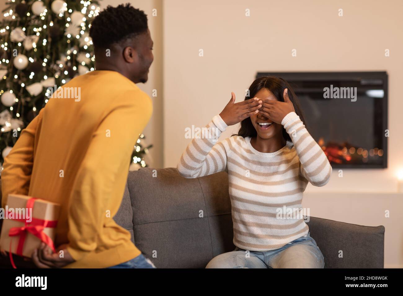 African Boyfriend Holding Gift Box Congratulating Wife Celebrating Valentine Indoor Stock Photo