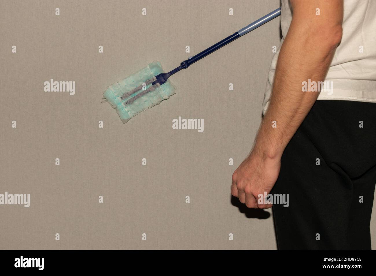 Vaduz, Liechtenstein, December 23, 2021 Person is wiping over the surface of a white wall Stock Photo