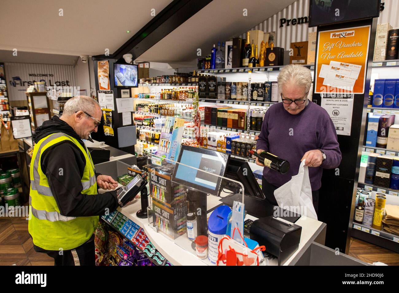 Seamus McNamee, the director of the First and Last off-licence in Jonesborough, just south of Newry in Northern Ireland serving a customer. Minimum unit alcohol pricing comes into effect in Ireland from Tuesday which could drive customers to travel from Ireland crossing the border to purchase lower priced alcohol. Picture date: Tuesday January 4 2021. Stock Photo