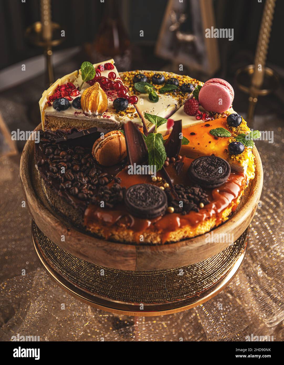 Different slices of various cakes, making a single whole torte on cake stand Stock Photo
