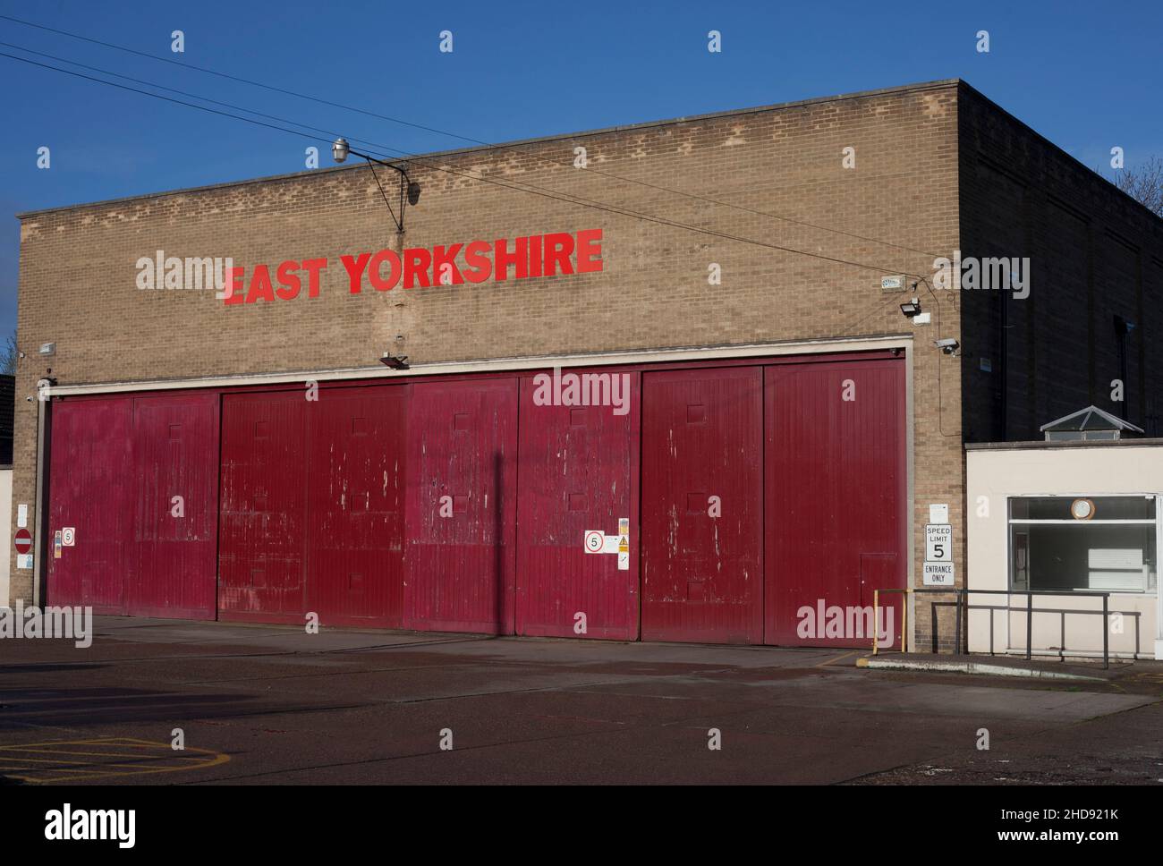 Old 1960s bus depot garage with red doors and East Yorkshire bright red sign at Elloughton, Brough East Yorkshire UK Stock Photo