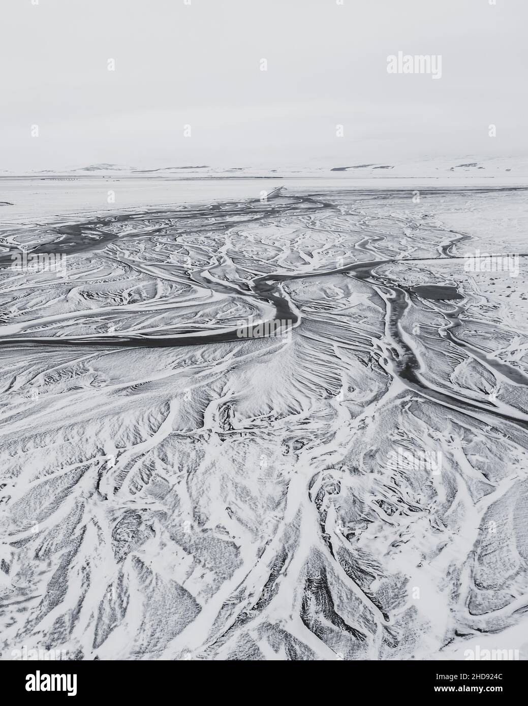 Aerial view of a snowy land with a frozen river Stock Photo - Alamy