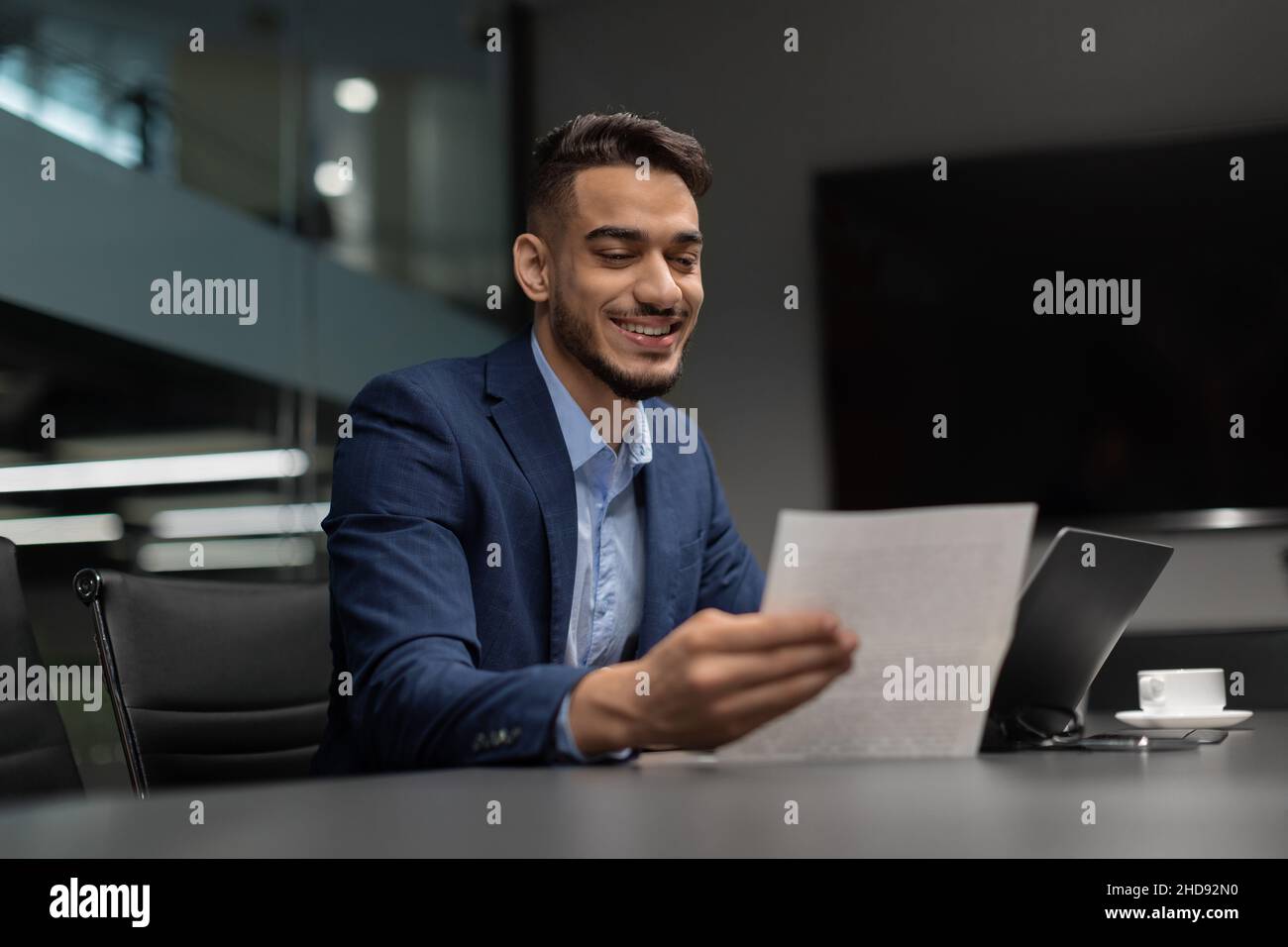 Smiling arabic businessman checking reports in modern office Stock Photo