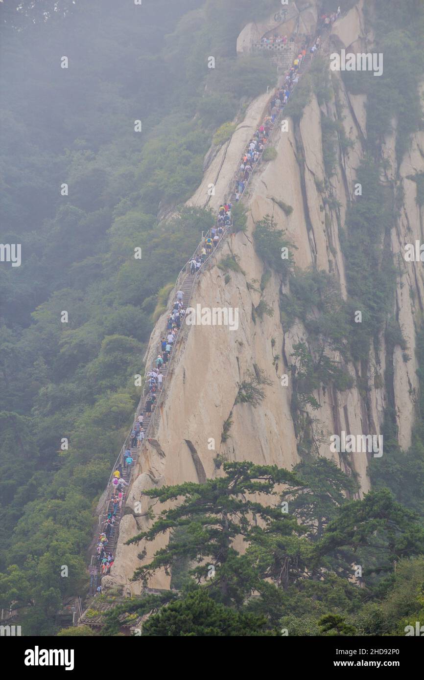 People climb at the stairs leading to the peaks of Hua Shan mountain in Shaanxi province, China Stock Photo