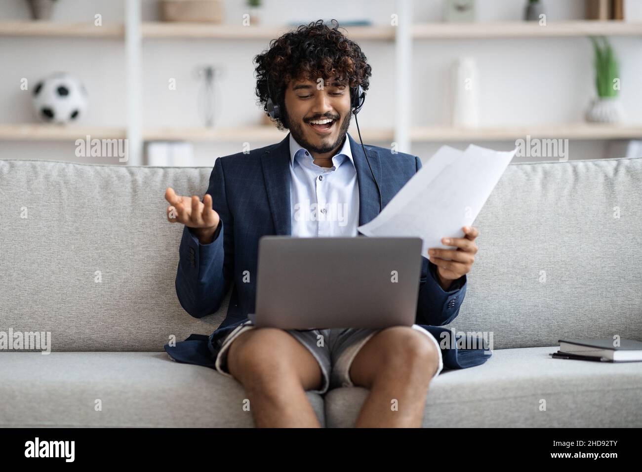 Positive indian employee having video conference, home interior Stock Photo