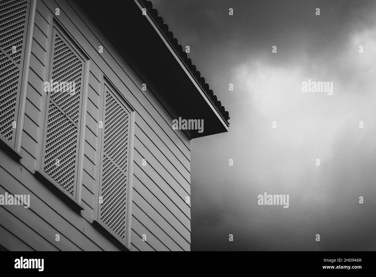 Grayscale shot of the house wall against the sky. Stock Photo