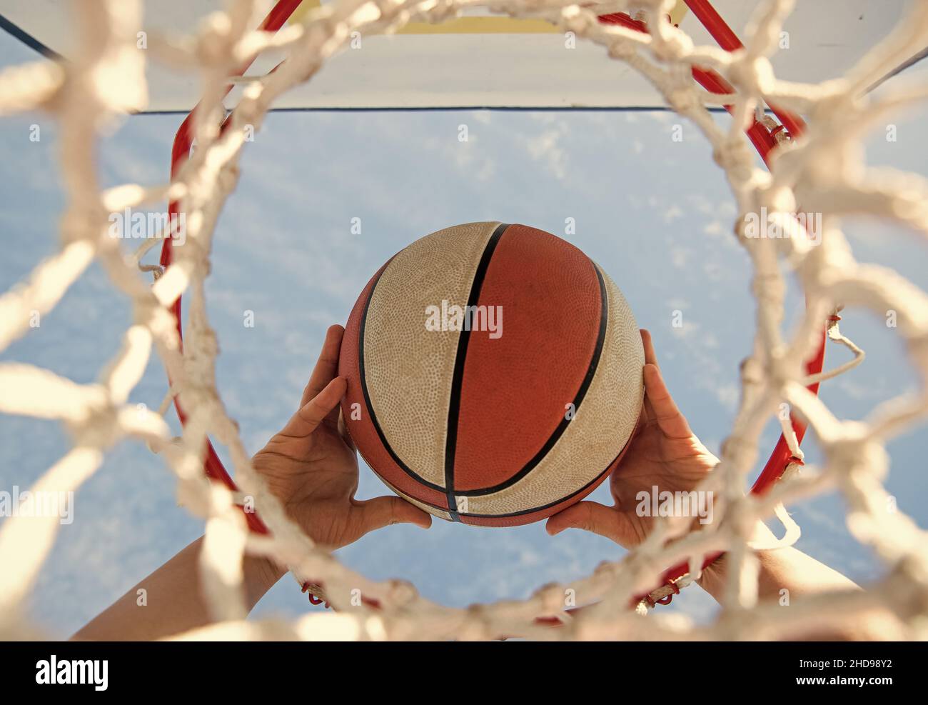 ball goes through basket. man throwing ball in hoop. hands and basketball. dunk in basket Stock