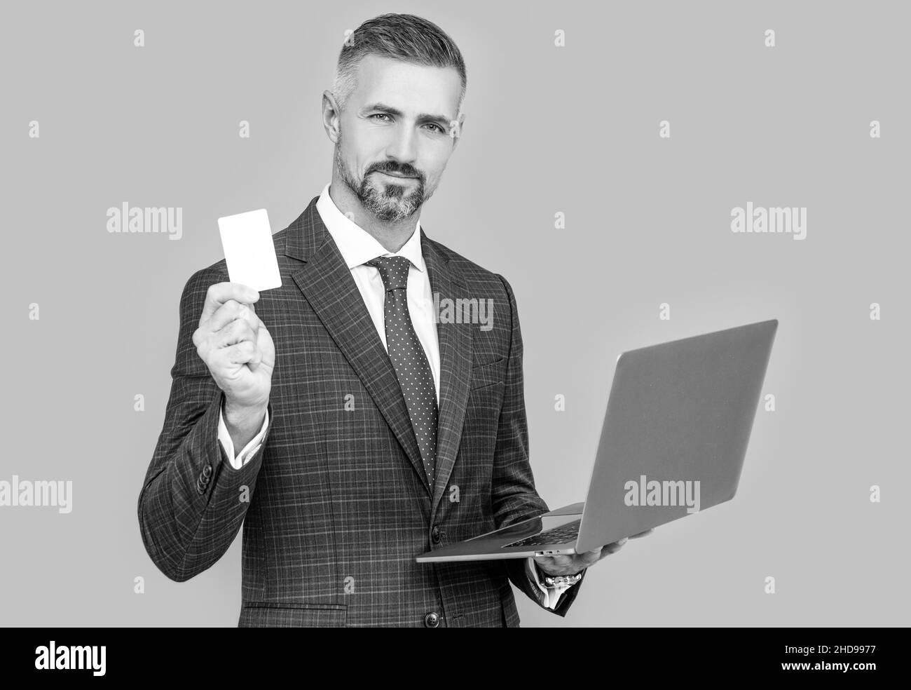 confident businessman man in businesslike suit hold laptop and debit card, shopping online Stock Photo