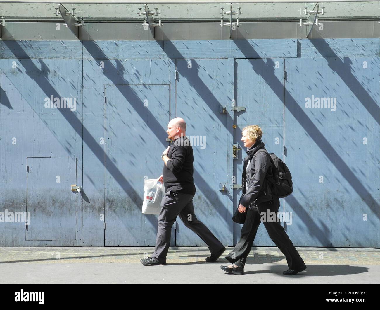 Parallel Lines - a middle aged couple walking in tandem in London Stock Photo