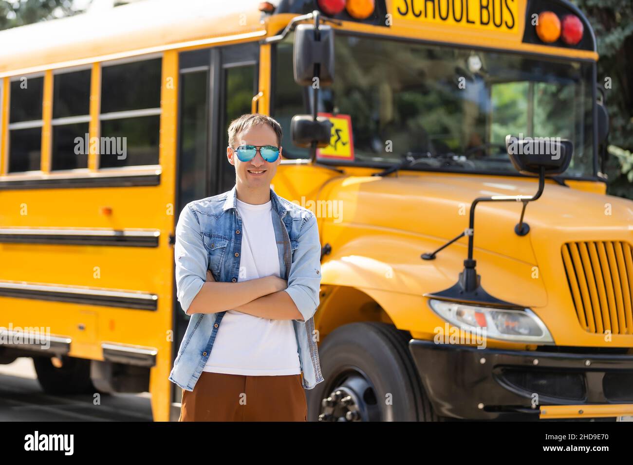 Portrait of smiling teacher near school bus Stock Photo - Alamy