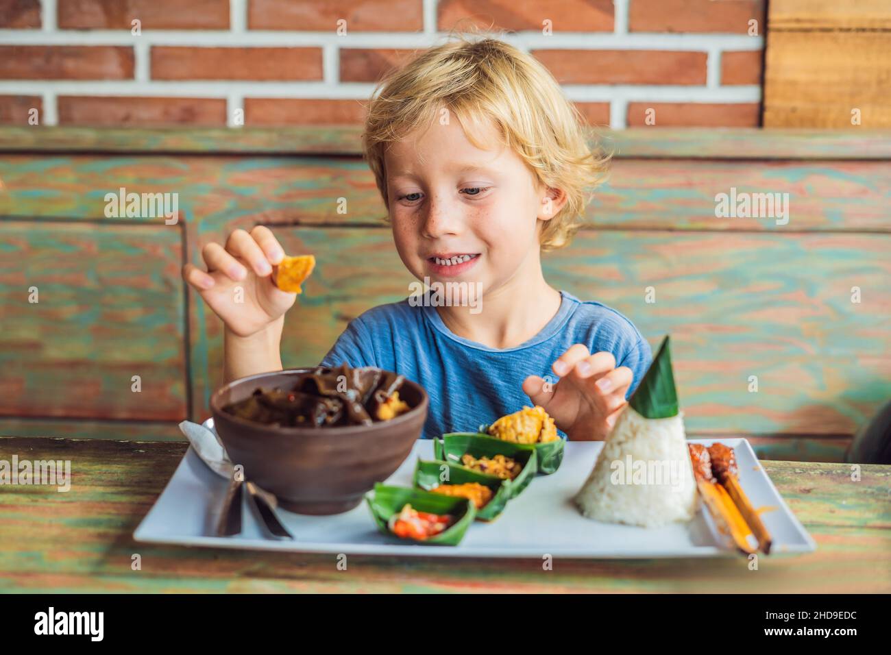 Boy eats in a cafe. Lifestyle. A dish consisting of rice, fried fish