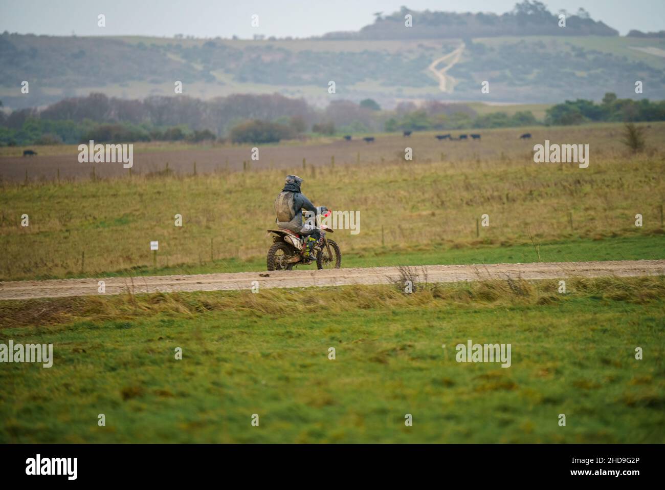a motor cyclist (biker) riding his offroad motorbike along a stone
