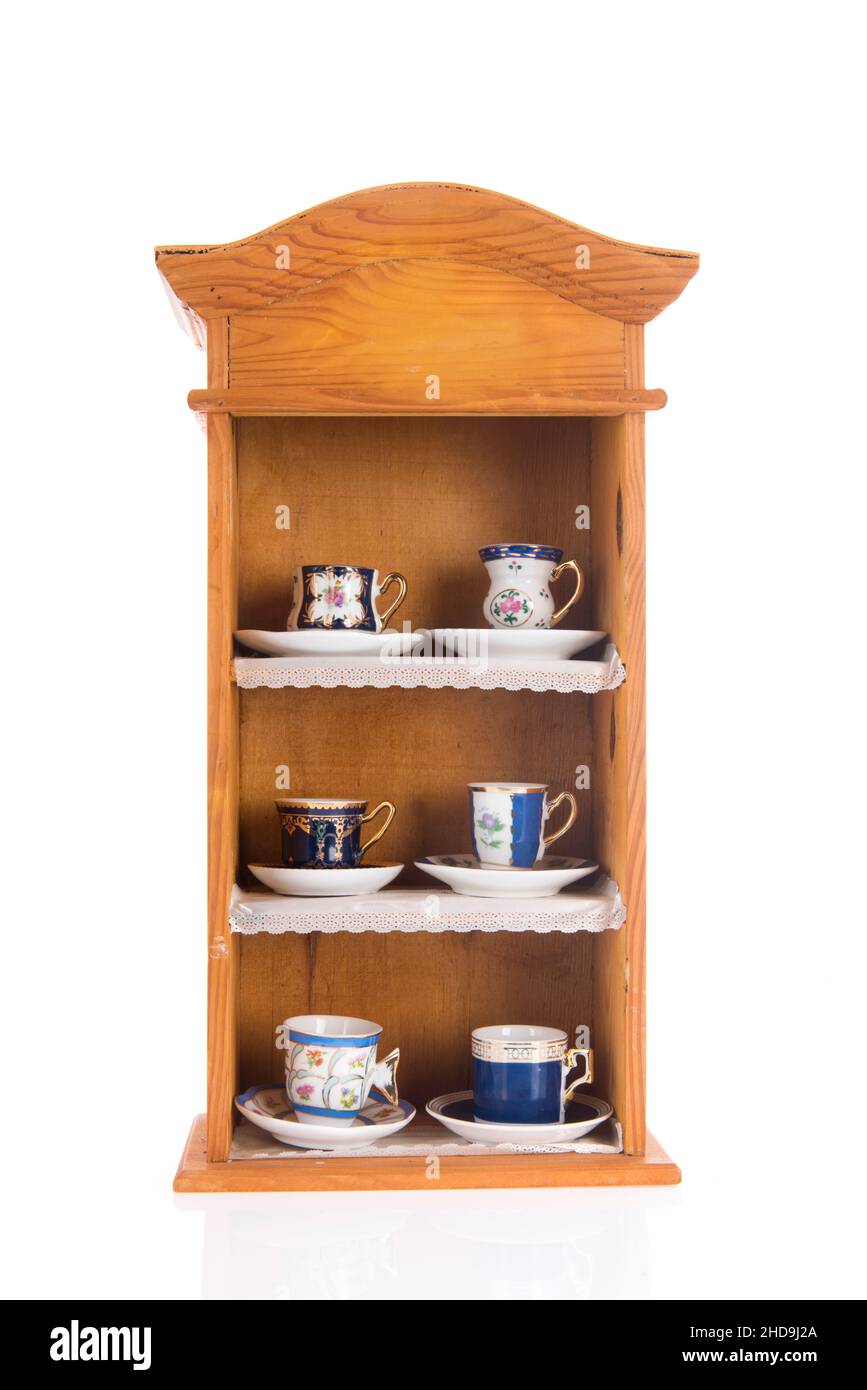 Cupboard with vintage cups and saucers isolated over white background