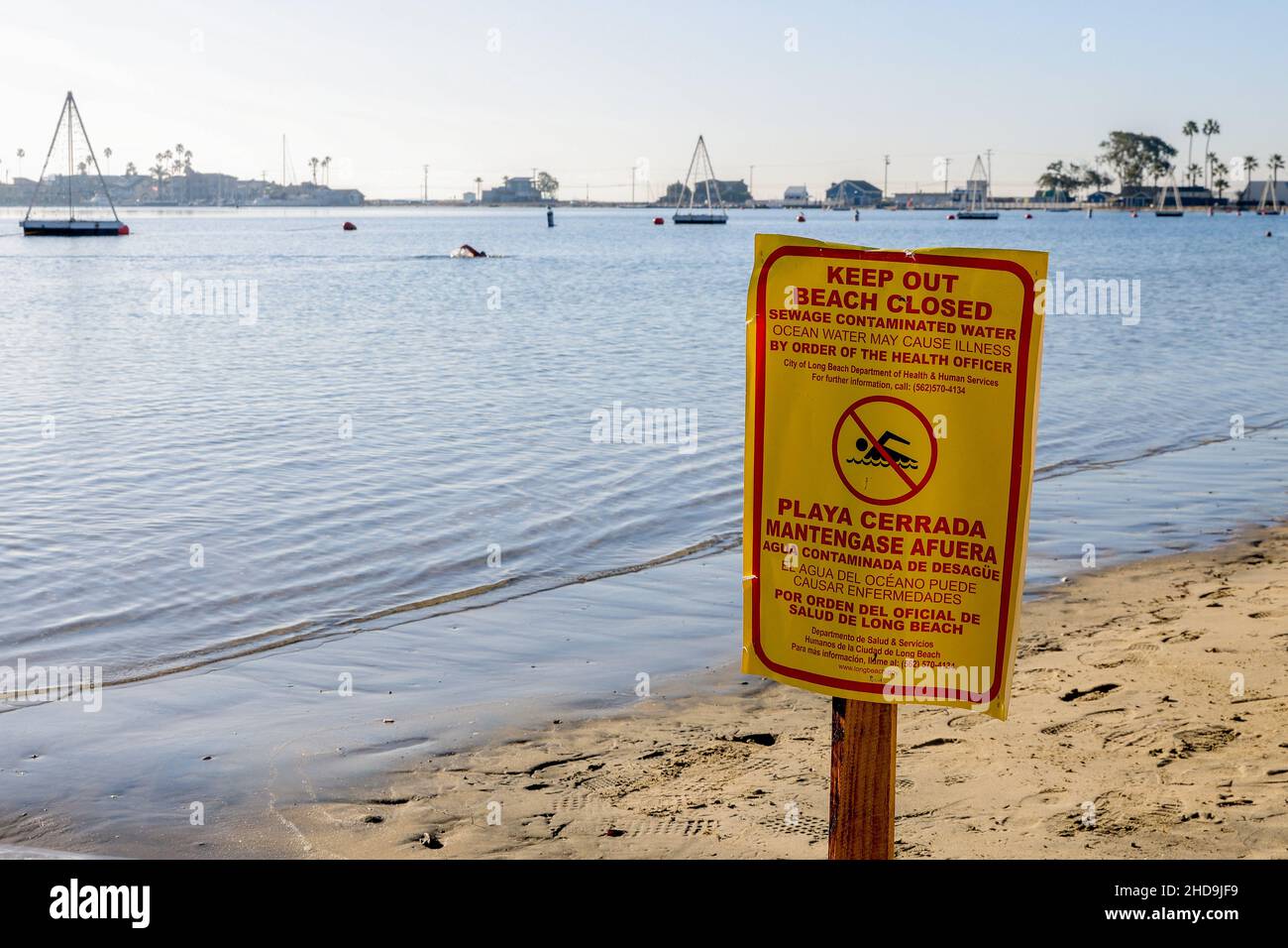 Long Beach, California, USA. 4th Jan, 2022. January 4th, 2022, Long Beach, California, USA: The City of Long Beach posted only a few signs in response to massive sewage spill. The spill was reported on December 30th when a 48-inch sewer mainline failed during the recent winter storm, leaking sewage into the waterway that empties into Los Angeles Harbor.Despite posted signs, some swimmers were still entering the water. (Credit Image: © Ron Lyon/ZUMA Press Wire) Stock Photo