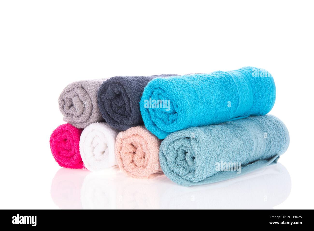 Many rolled towels with soap isolated over white background Stock Photo