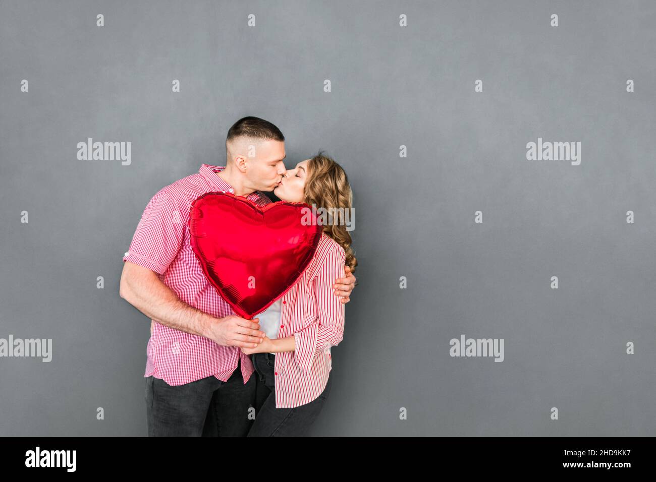 Beautiful couple holding heart balloon in their hands Stock Photo - Alamy