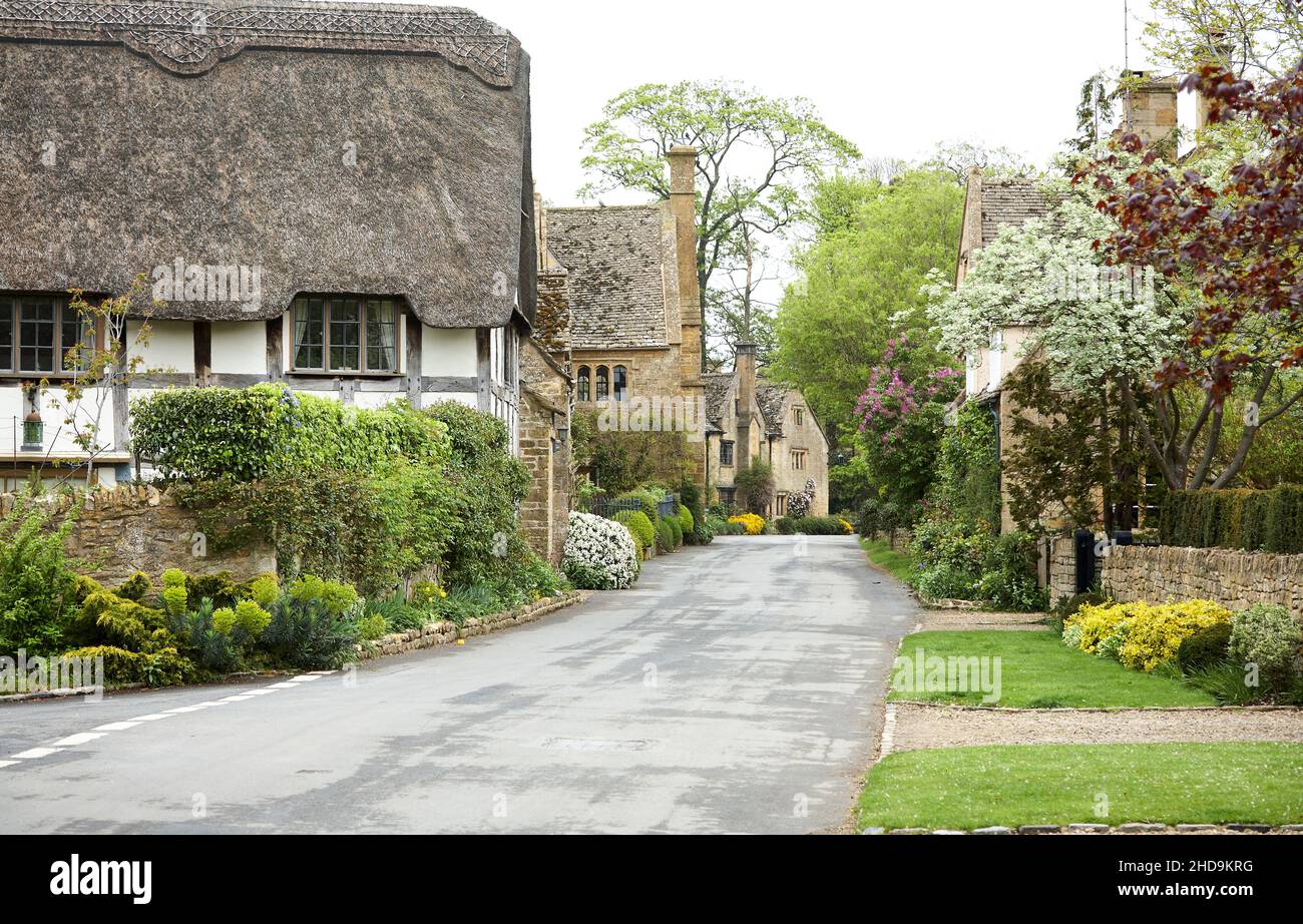 Thatched Cottage and street view in  17th century village of Stanton. Stock Photo