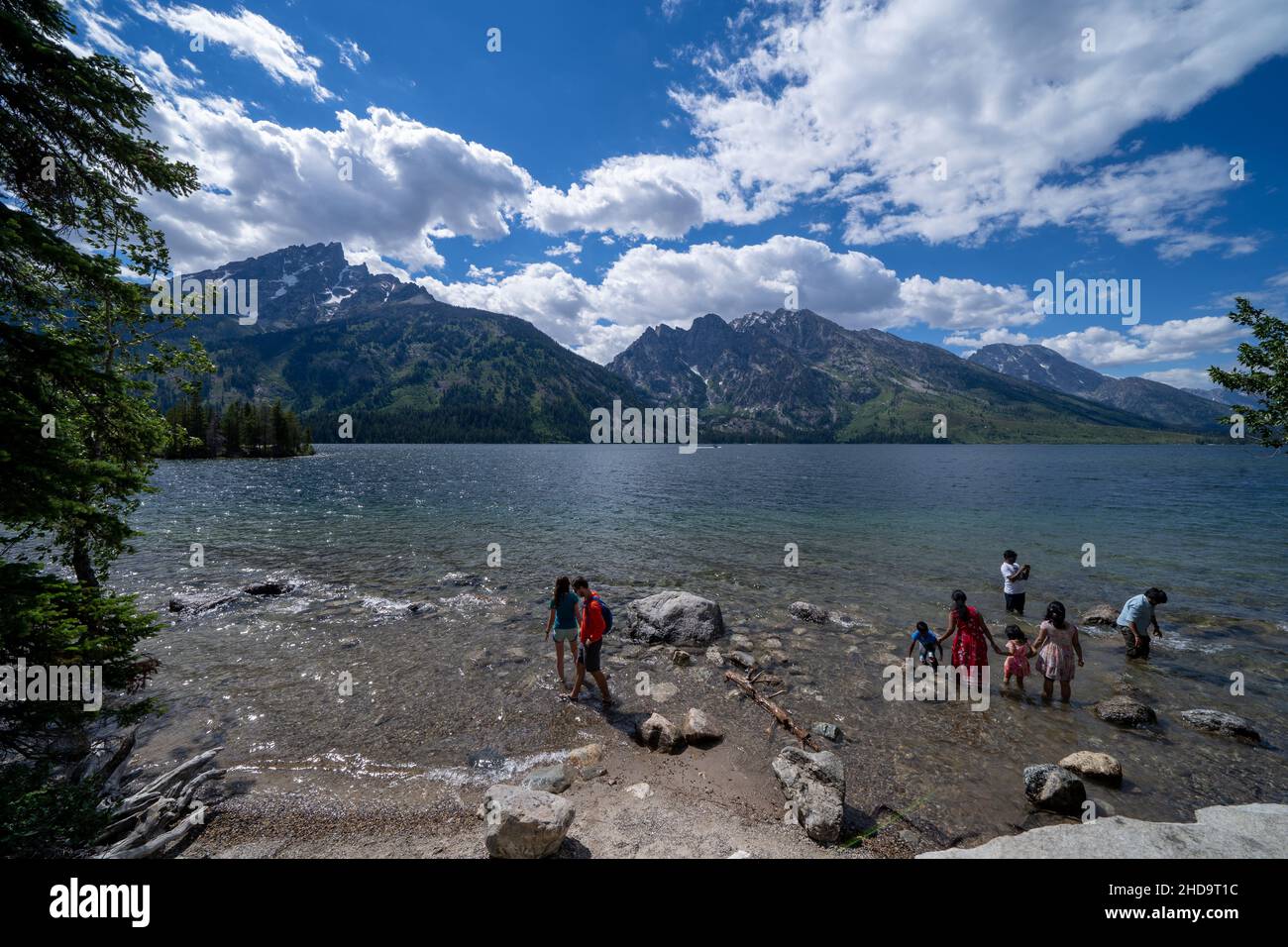 Wyoming, USA - June 27, 2021: Tourists wade in Jenny Lake at Grand Teton National Park Stock Photo