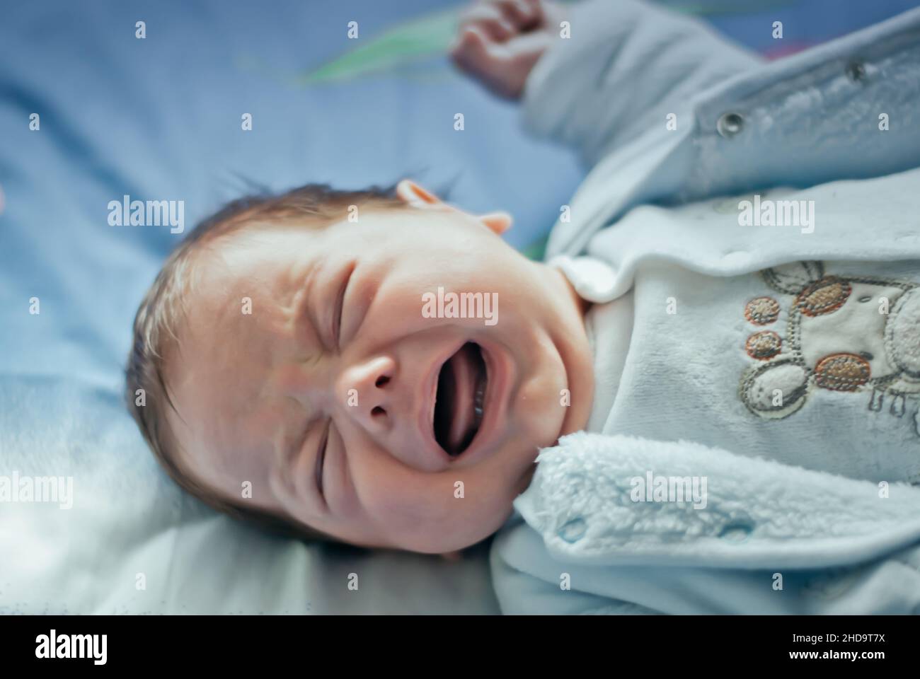 Newborn crying baby boy  on the bed Stock Photo