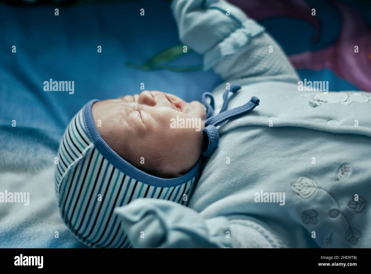 Newborn crying baby boy on the bed Stock Photo
