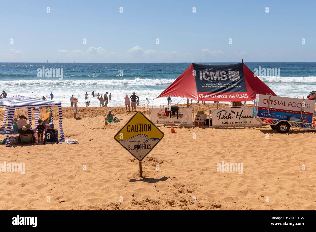 Newport Beach in Sydney, summers day with caution bluebottles sign erected and surf rescue tent - swim between the flags- Sydney,Australia Stock Photo