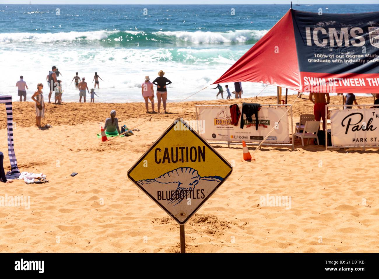 Newport Beach in Sydney, summers day with caution bluebottles sign erected and surf rescue tent - swim between the flags- Sydney,Australia Stock Photo