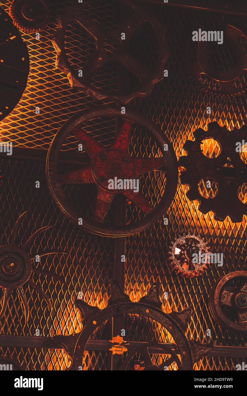 Closeup of industrial metal objects on a metal net wall, gears, wheels and Radiation Sign Stock Photo