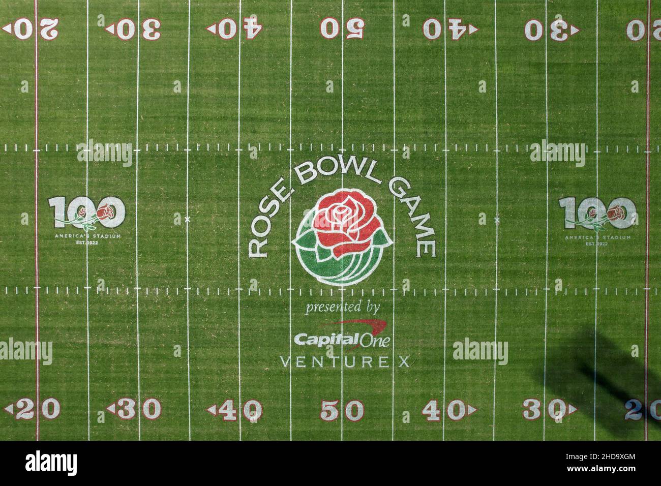 An aerial view of the Rose Bowl Stadium football field with the logos
