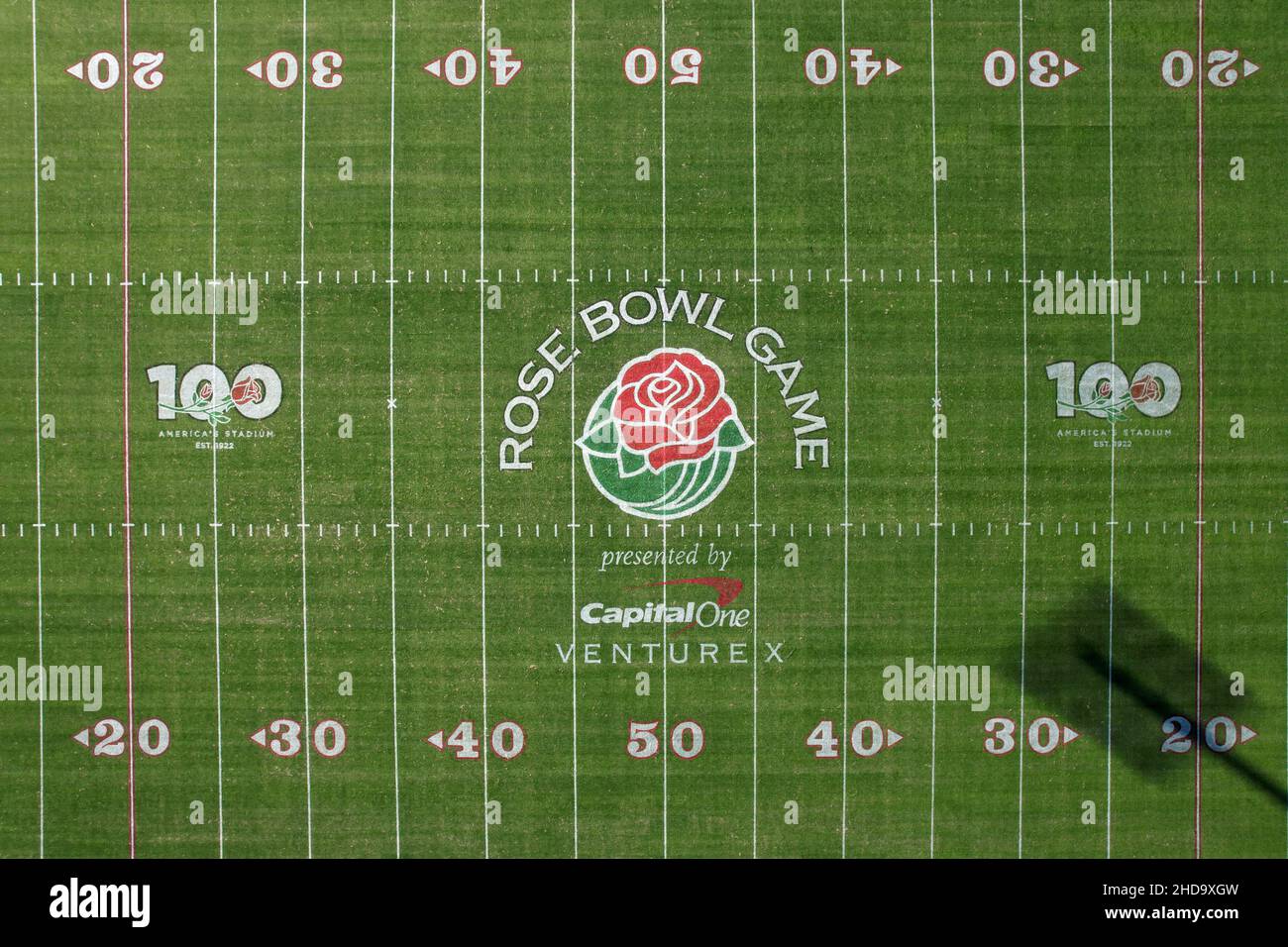 An aerial view of the Rose Bowl Stadium football field with the logos