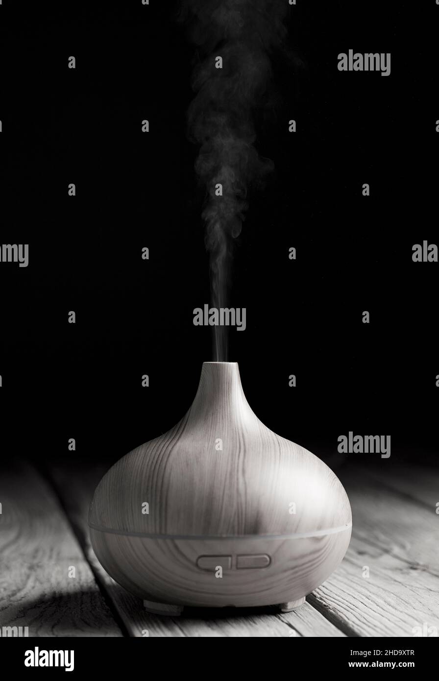 Essential oil diffuser, made of wood with elegant and soft curves, black and white. Stock Photo