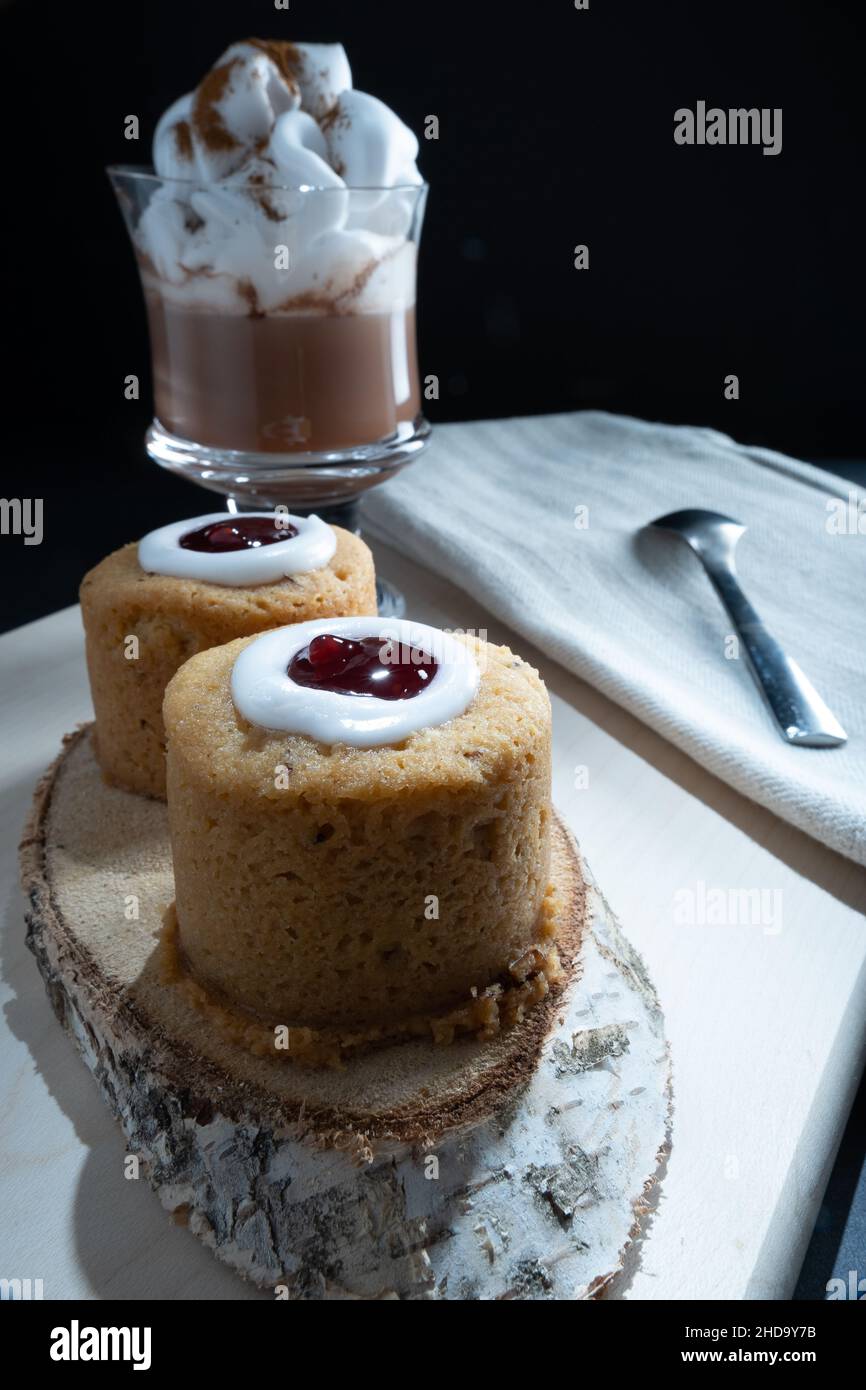 Helsinki / Finland - JANUARY 4, 2022: Traditional Finnish foods: Closeup of Runeberg torte with raspberry topping. A cup of hot chocolate on the side. Stock Photo