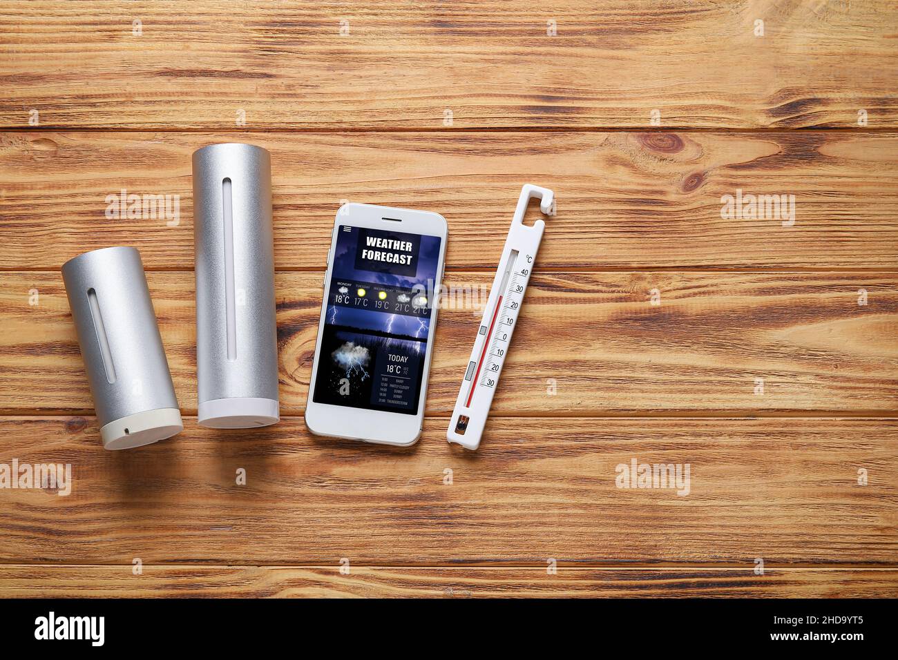 Weather forecast equipment and mobile phone with thermometer on wooden