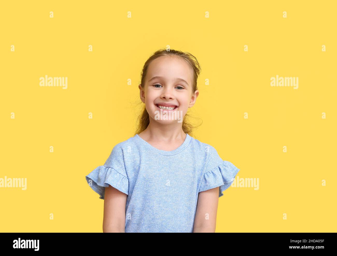 Portrait of smiling little girl on yellow background Stock Photo - Alamy