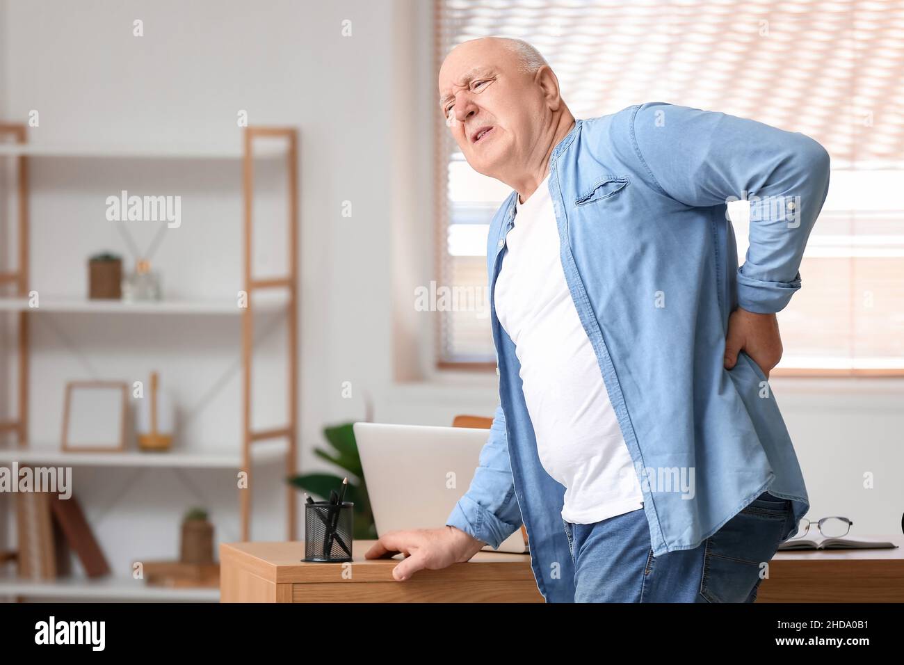 Senior man suffering from back pain near table at home Stock Photo - Alamy