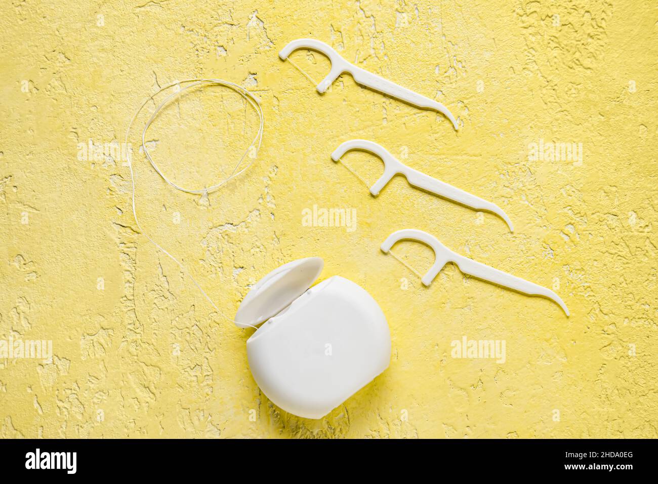 Dental floss with toothpicks on yellow background Stock Photo - Alamy