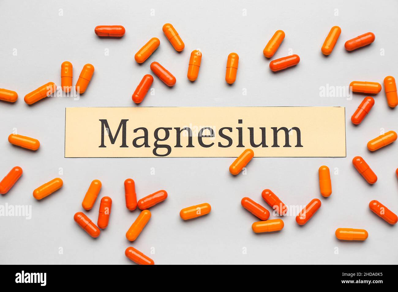 Colorful capsules and word MAGNESIUM on light background Stock Photo