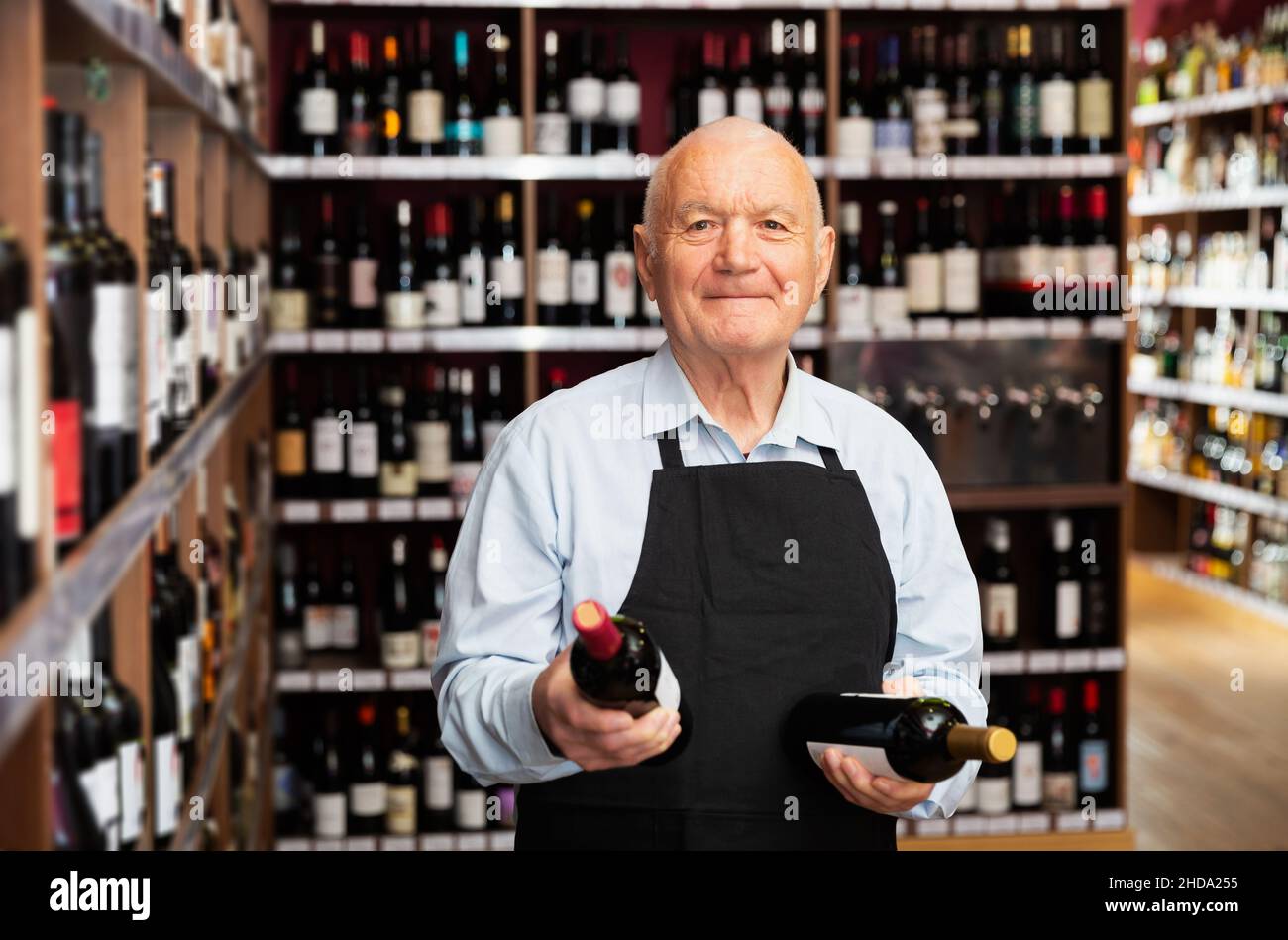 vintner offering wine in modern wineshop Stock Photo