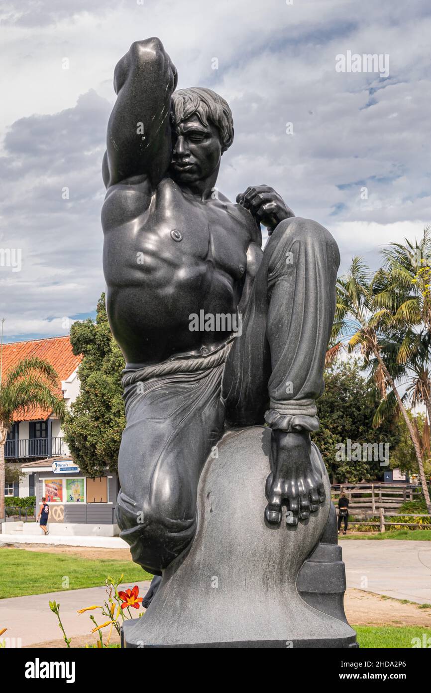 San Diego, California, USA - October 4, 2021: Closeup on black stone Morning statue by Donald Hord on pedestal in front of Wild blue-gray cloudscape,. Stock Photo