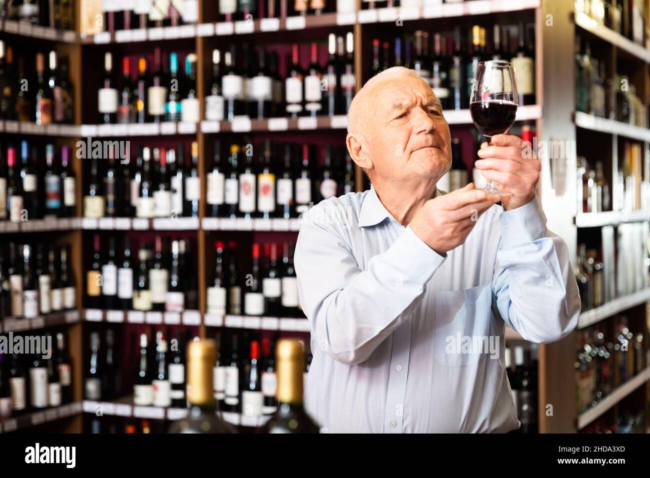 Portrait of senior man tasting red wine at wine shop Stock Photo - Alamy