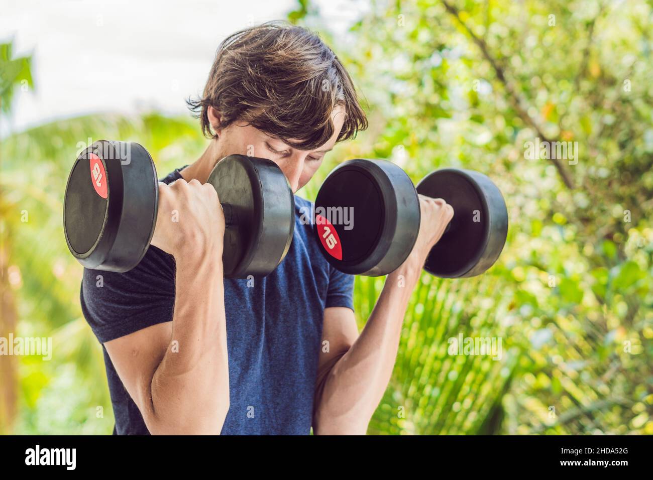 Bicep curl weight training fitness man outside working out arms lifting dumbbells doing biceps curls. Male sports model exercising outdoors as part Stock Photo Alamy
