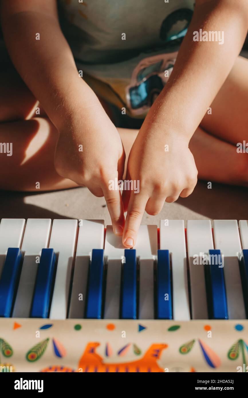 Close up portrait of hands of a child playing the piano. Children play