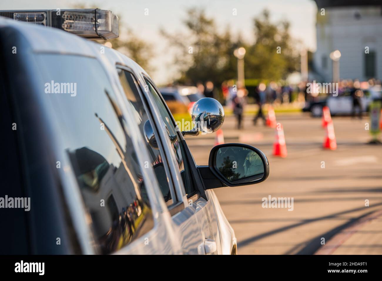 Local Police Supporting Large City Event. Police Cruiser Close Up and Some Crowd in a Background. Stock Photo