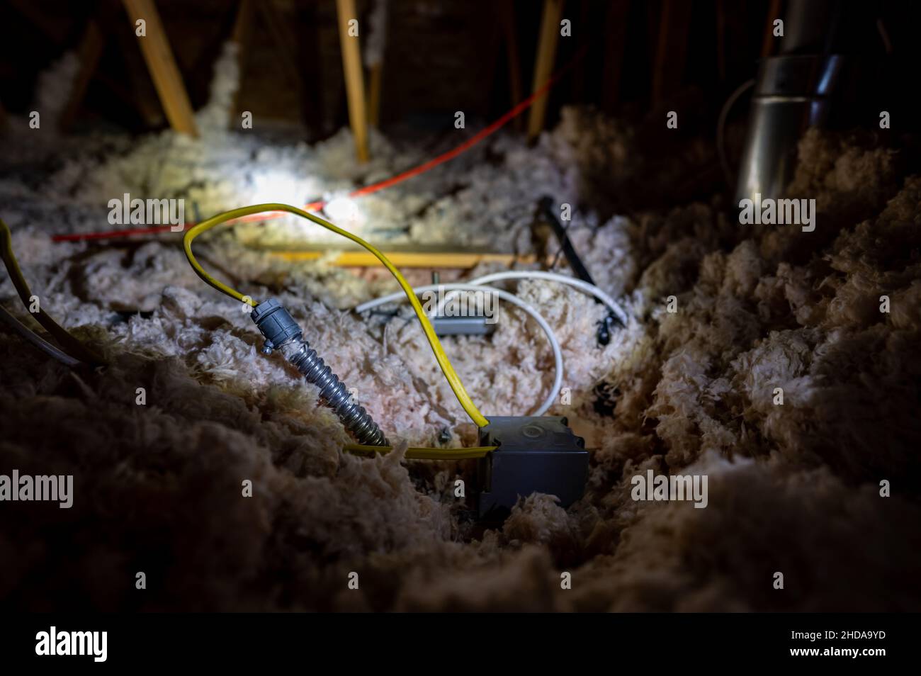 Electrical wire and conduit laying loose on blown insulation in a house attic Stock Photo Alamy