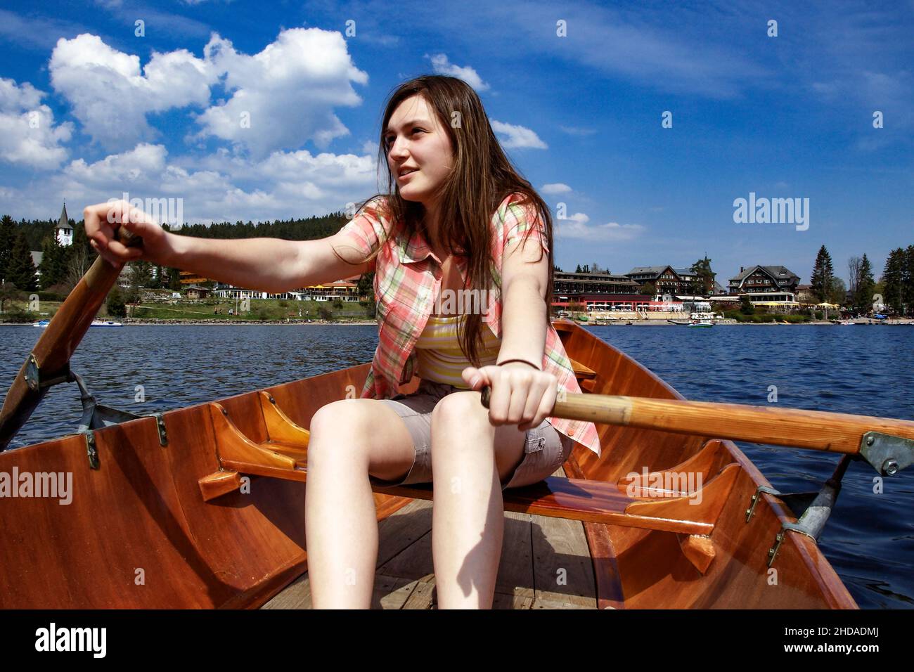 a young girl is rowing alone on the Titisee in the Black Forest Stock Photo