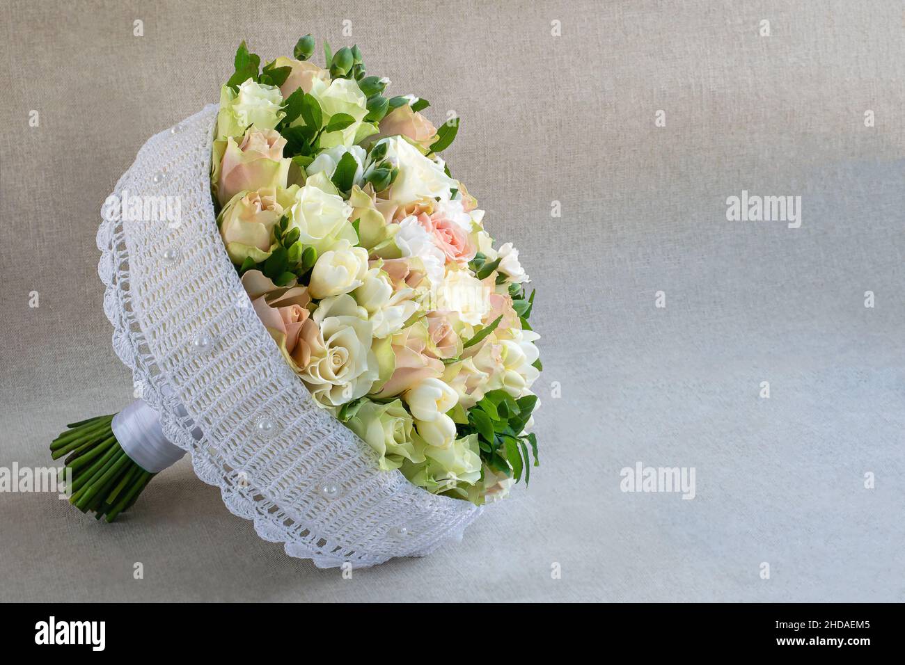 Round bridal bouquet on a handmade frame on a light background Stock Photo